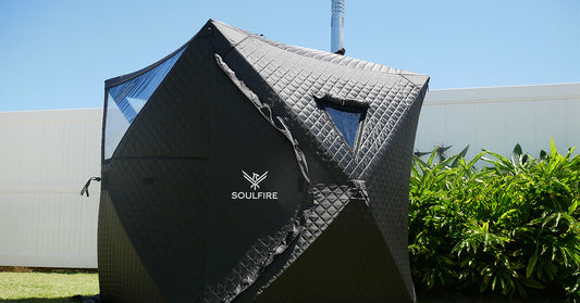 A portable woodfired steam sauna in a backyard on the grass